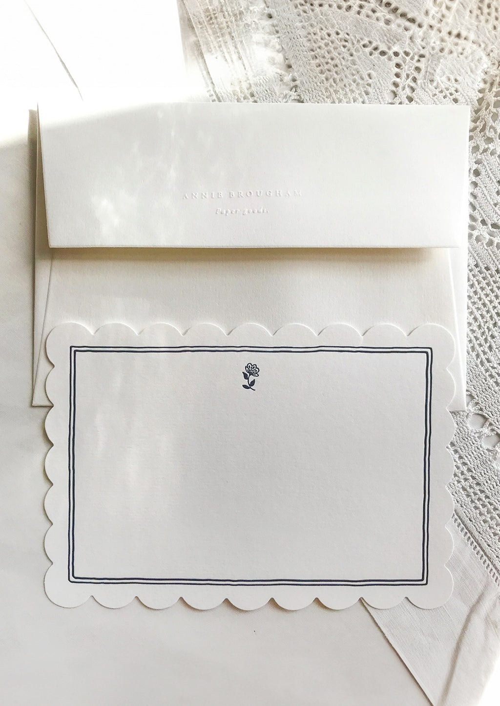Navy Border with Flower: A scalloped white notecard with navy border and white envelope.