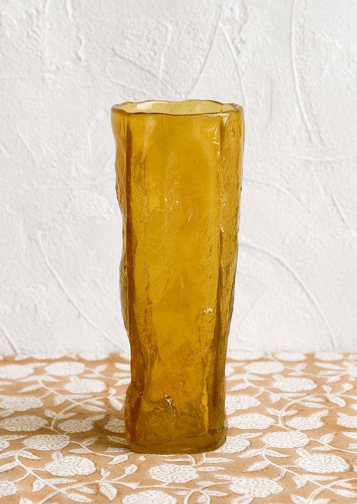 An amber glass vase with irregular texture and shape.