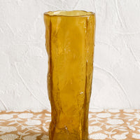 1: An amber glass vase with irregular texture and shape.