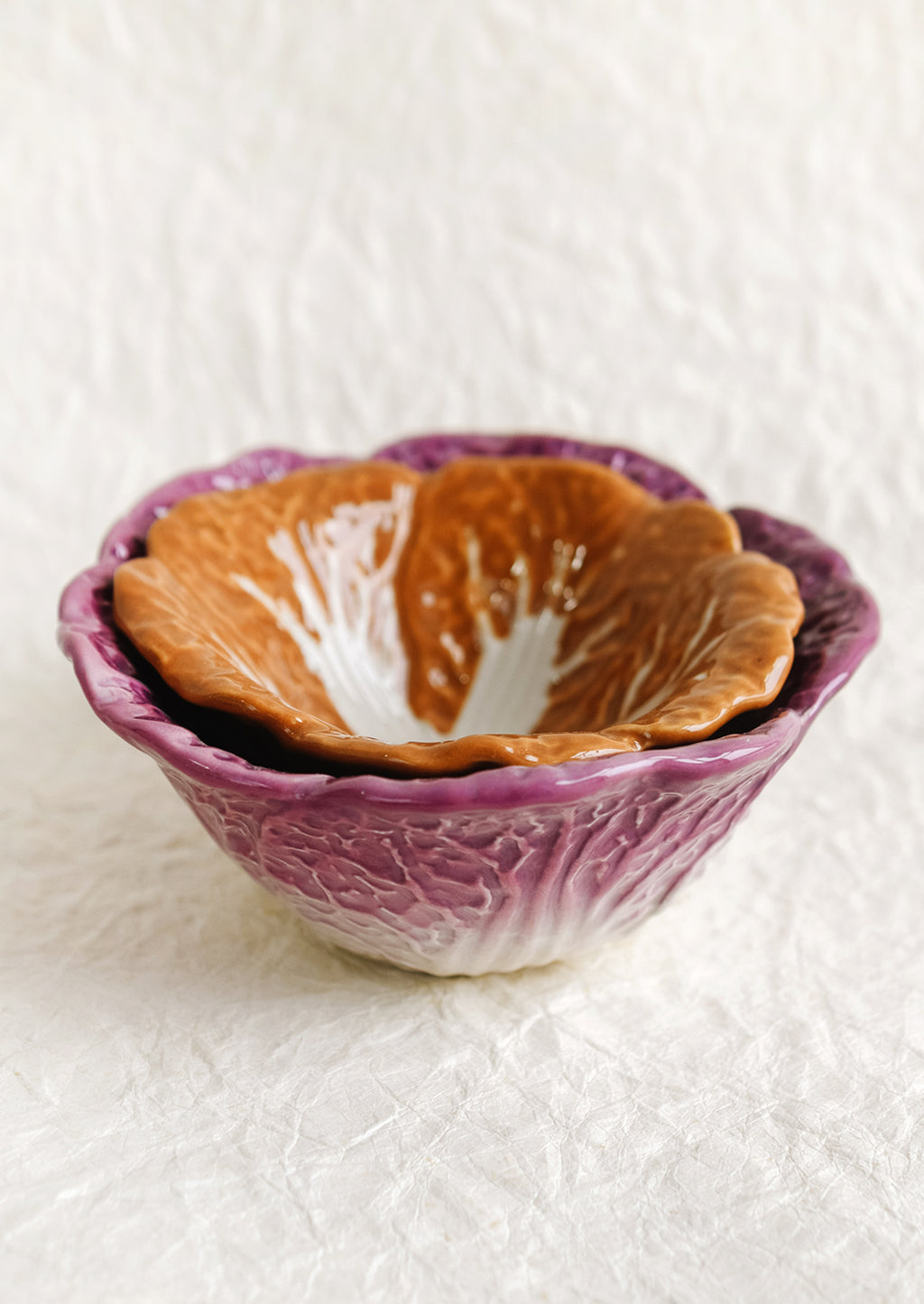 1: A pair of ceramic nesting bowls that look like orange and purple cabbage.