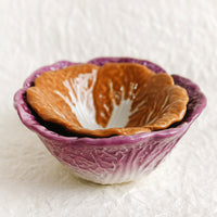 1: A pair of ceramic nesting bowls that look like orange and purple cabbage.
