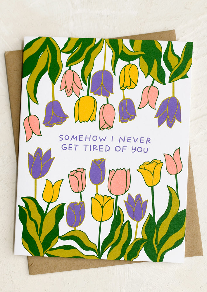 A tulip print card reading "Somehow I never get tired of you".