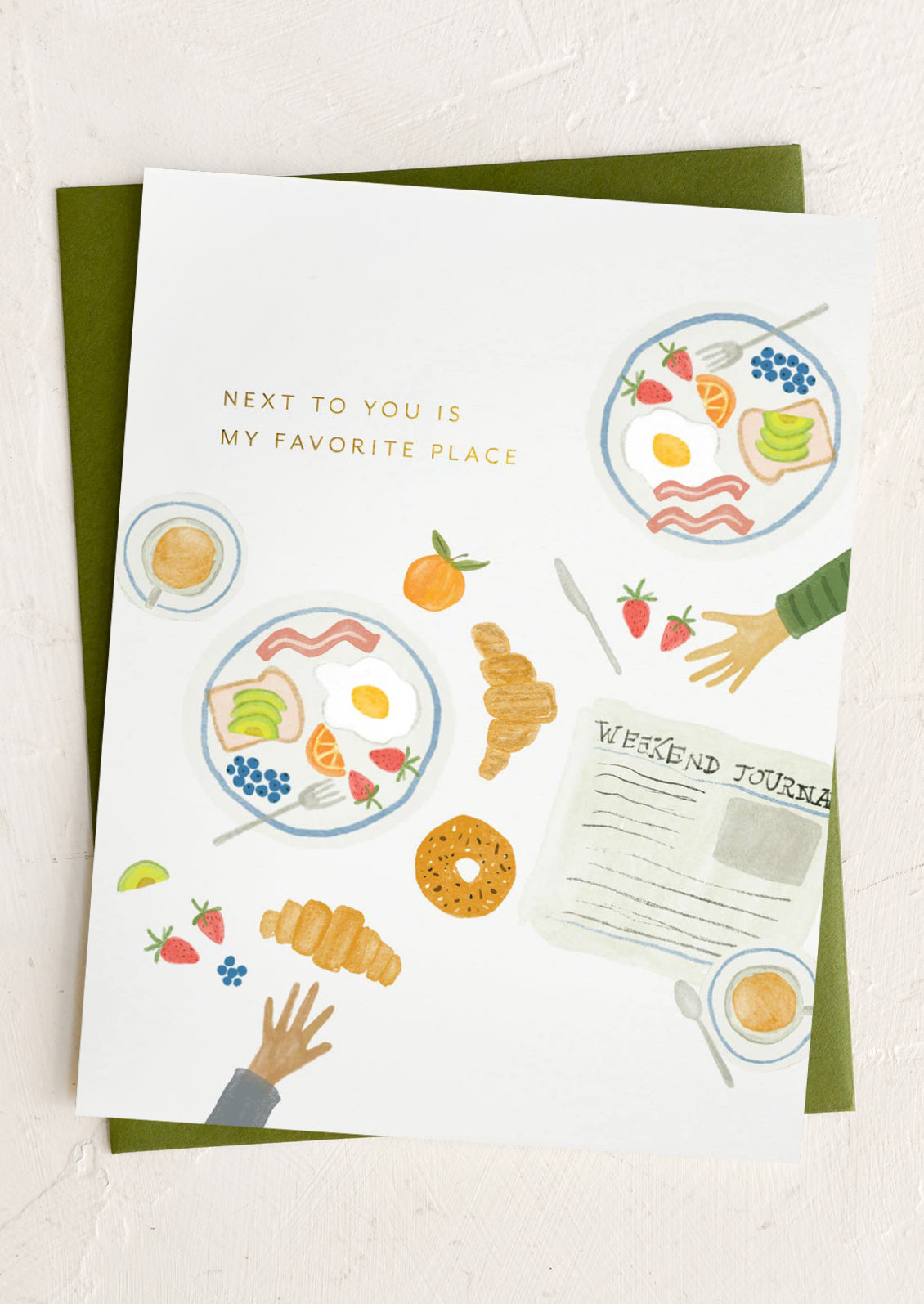 Greeting card with illustrations of food and hands, featuring text 'Next to you is my favorite place'.