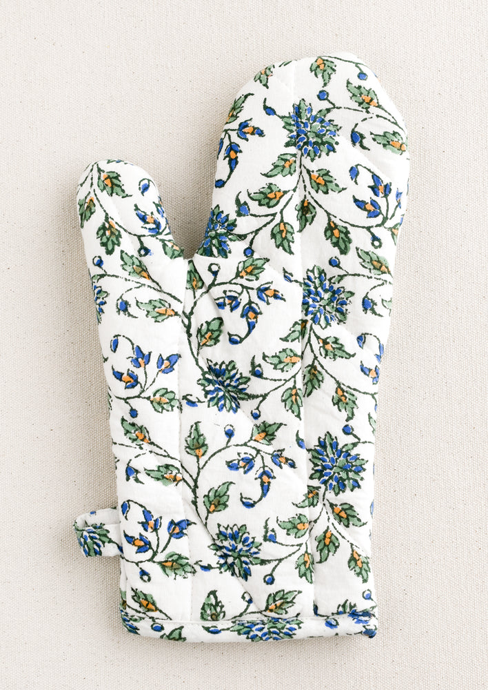 1: A quilted white cotton oven mitt with blue, green and orange floral pattern.