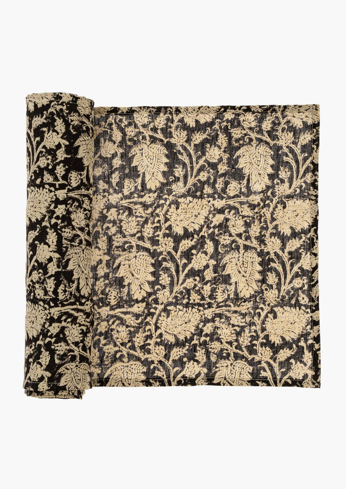 A linen table runner in black with cream block print motif.