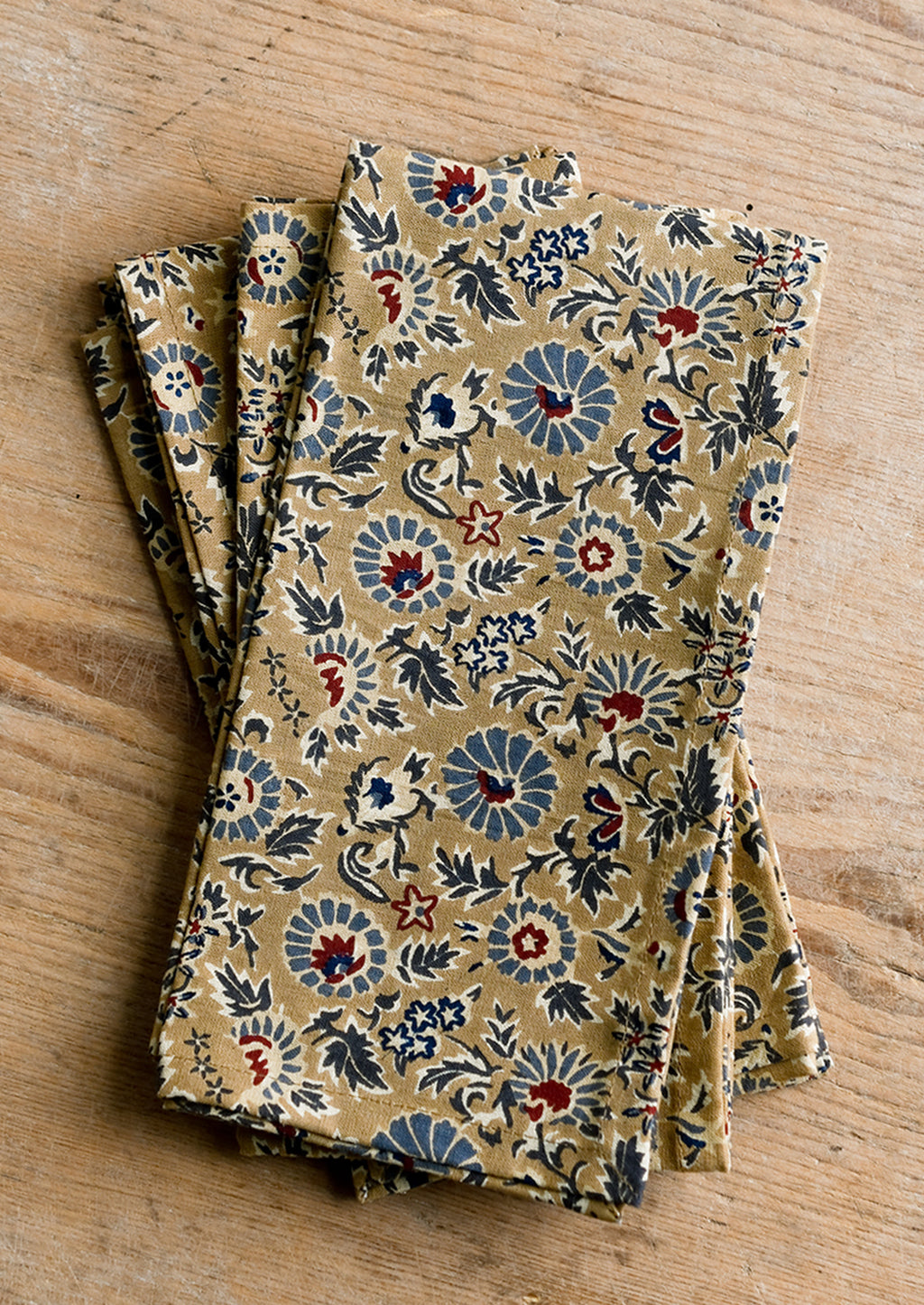 1: A floral print napkin set in brown, indigo and red.