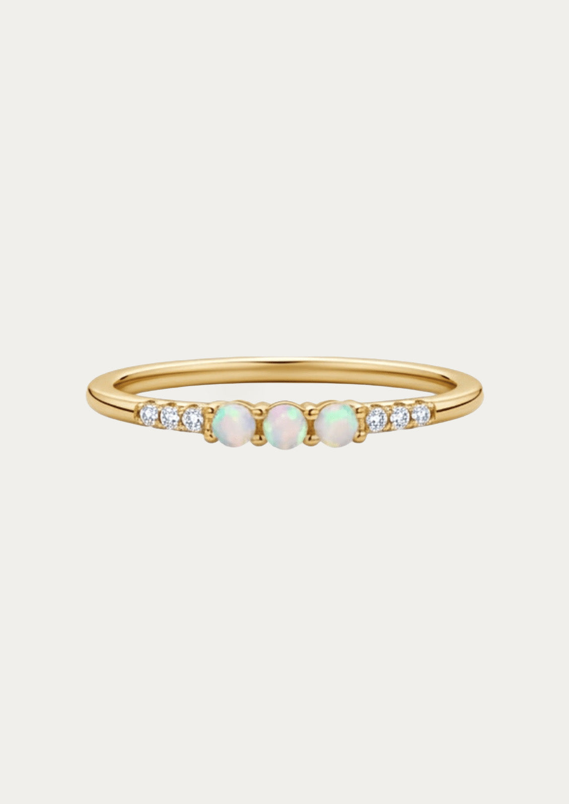 A gold ring adorned with three opals and cubic zirconia gems on either side.