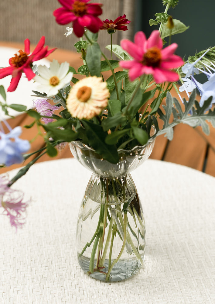 A glass vase with flowers.