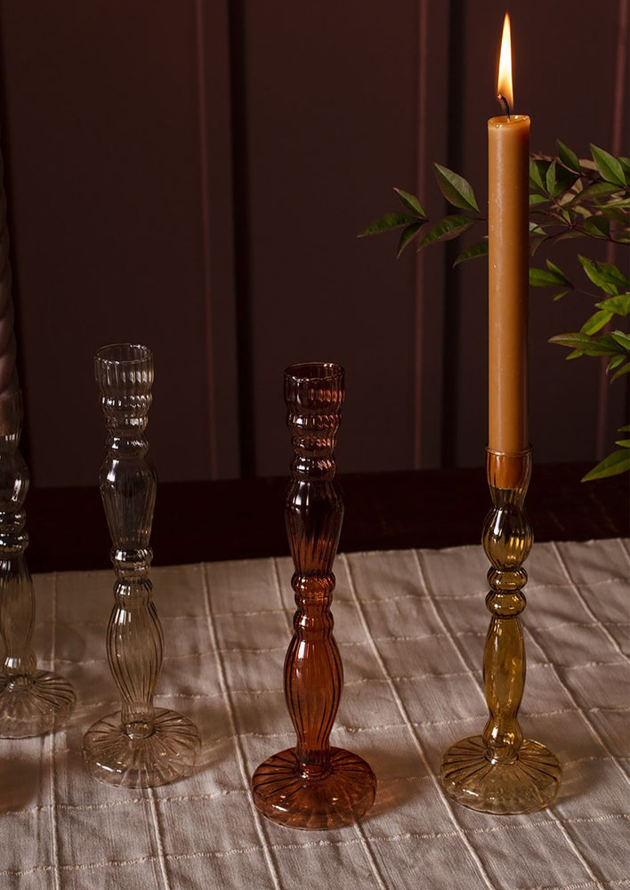 Assorted colors of optic glass candleholders with taper candles.
