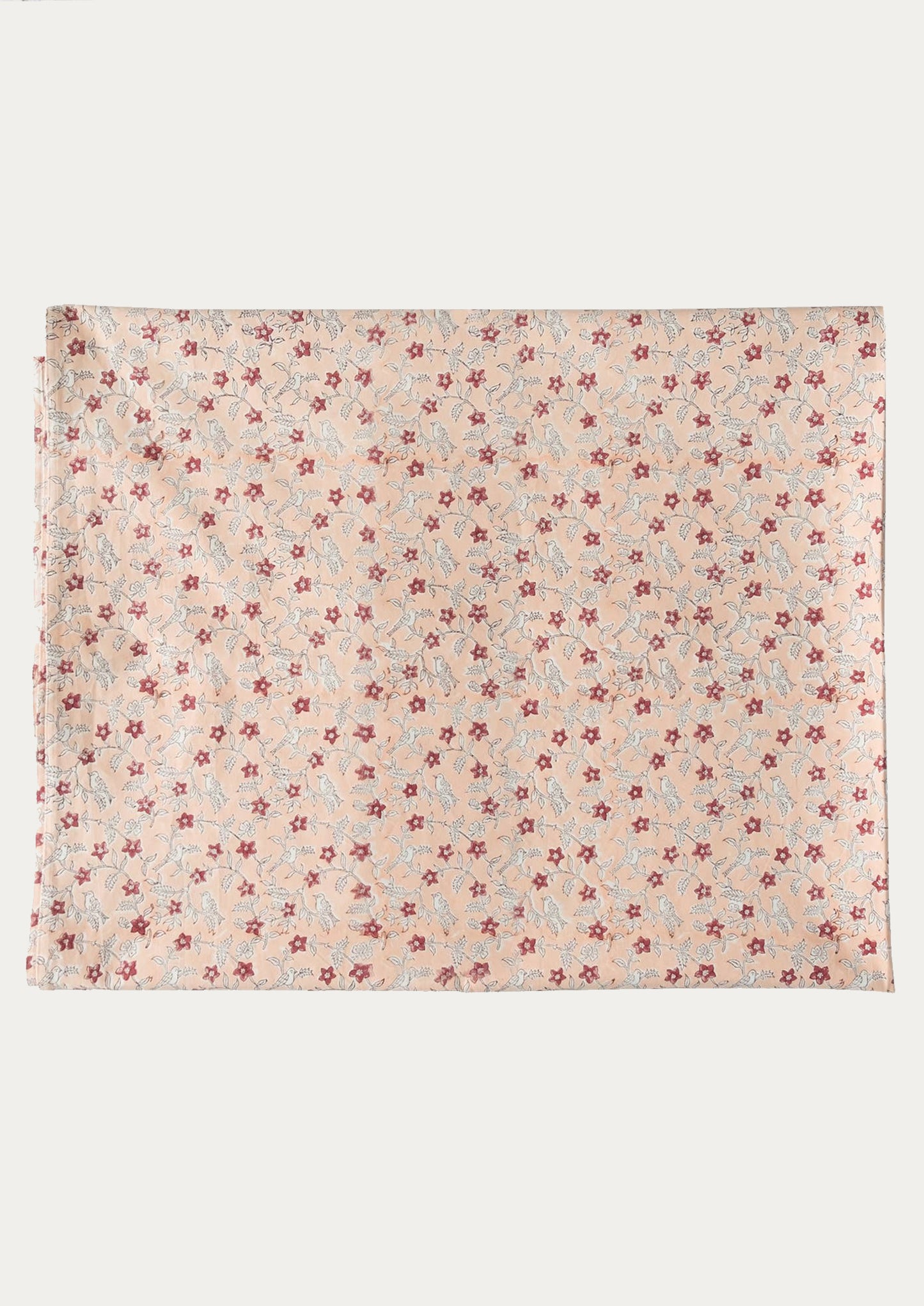 A folded tablecloth in peach floral pattern.