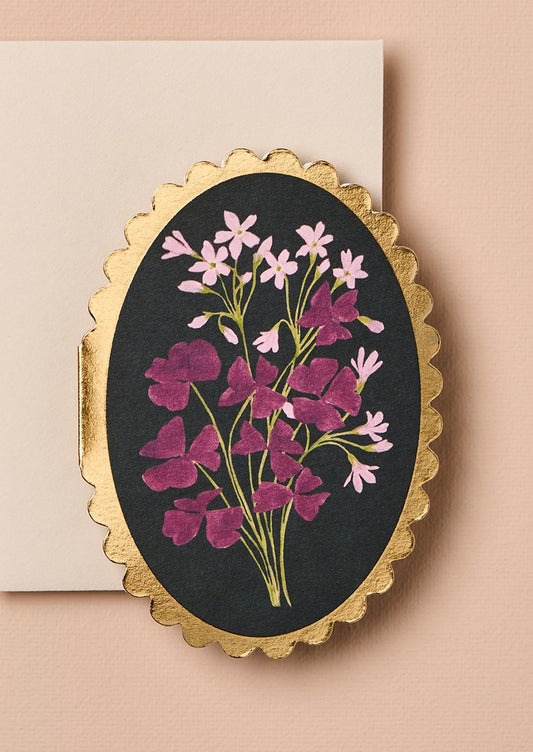 Decorative card with floral design and gold frame.