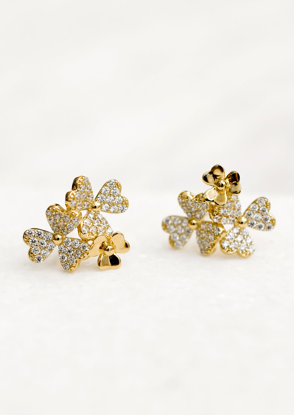 1: Gold stud earrings in shape of three flower cluster with clear crystals.