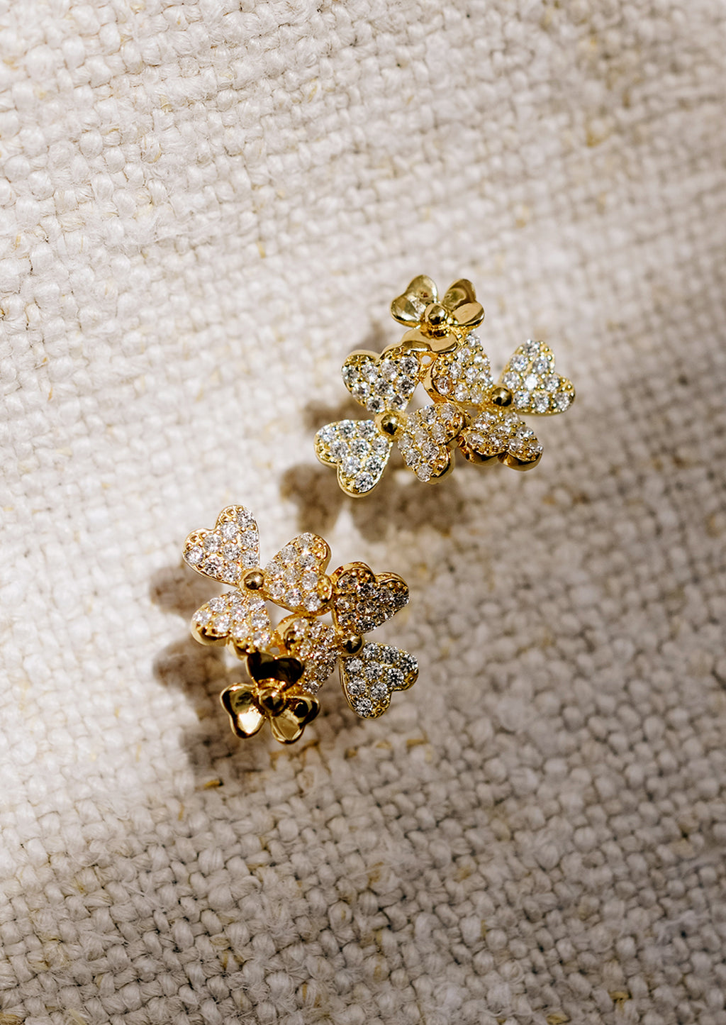 2: Gold stud earrings in shape of three flower cluster with clear crystals.