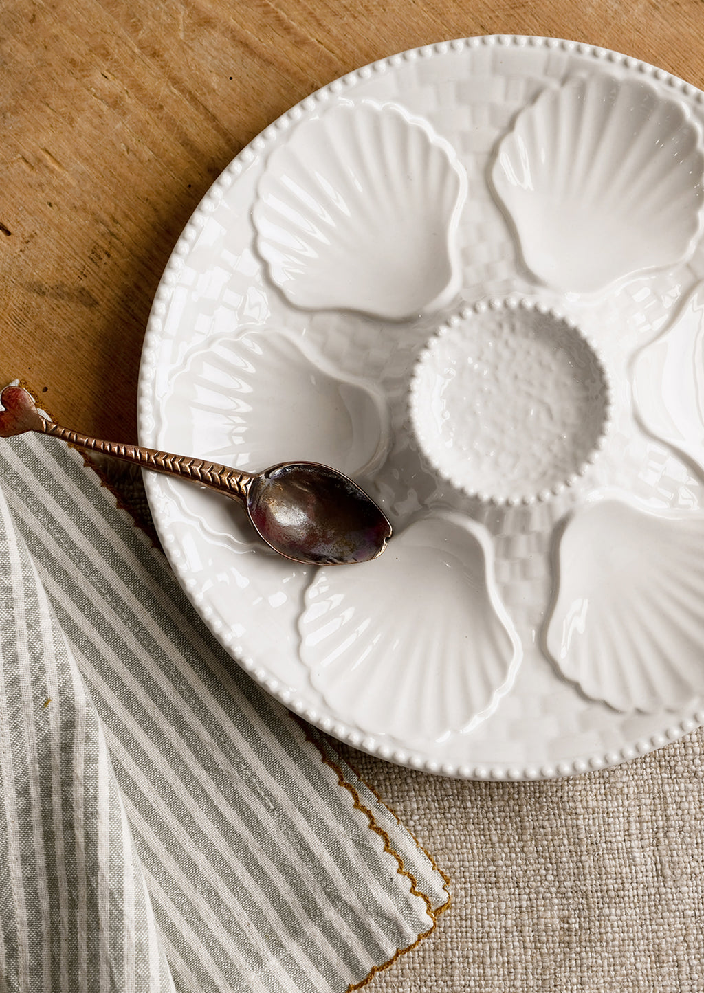 2: A glossy white ceramic plate with shell design.