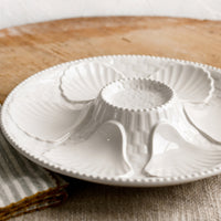 3: A glossy white ceramic plate with shell design.
