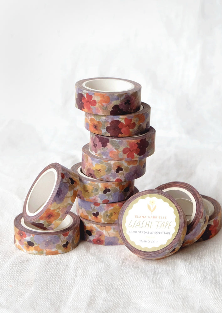 Stacks of colorful pansy print washi tape rolls.