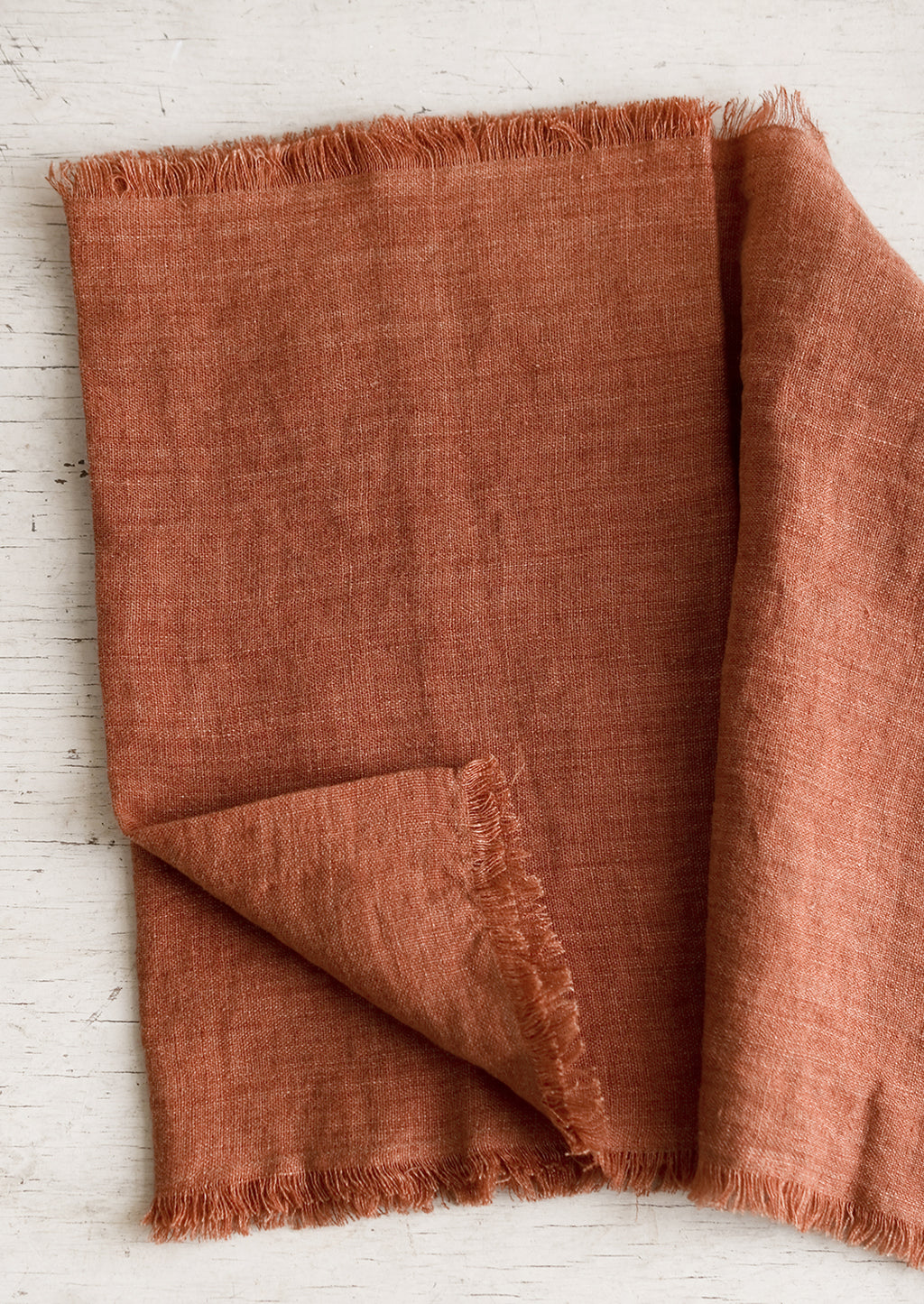 Paprika: A linen table runner with frayed edges in paprika.