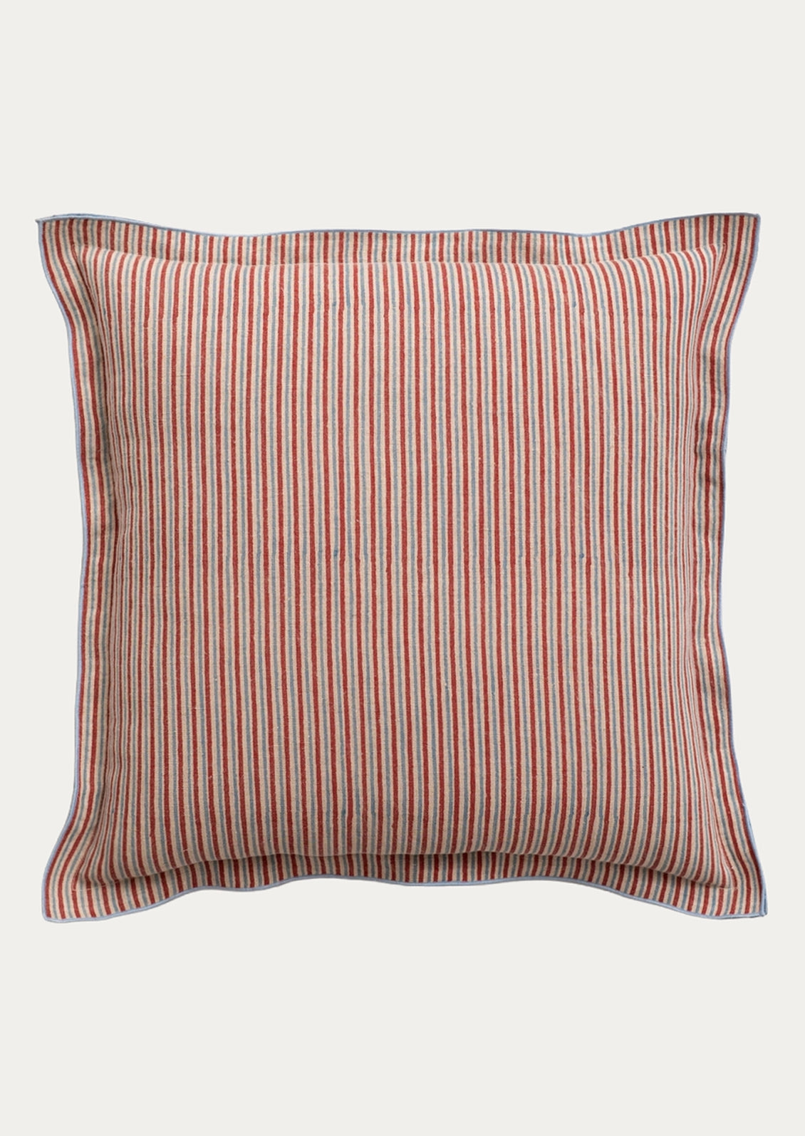 A square throw pillow with vertical red and blue stripes on a beige fabric background, finished with a solid blue piped border.