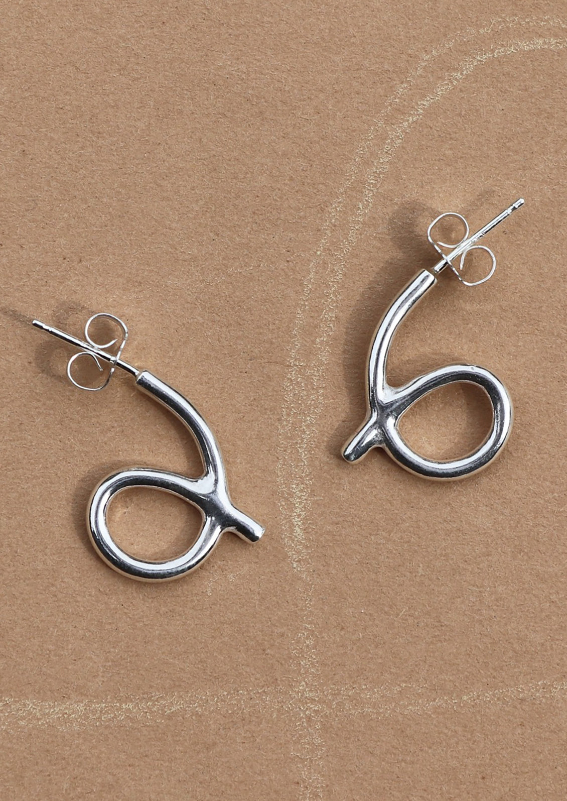 A pair of loop shaped sterling silver stud earrings.