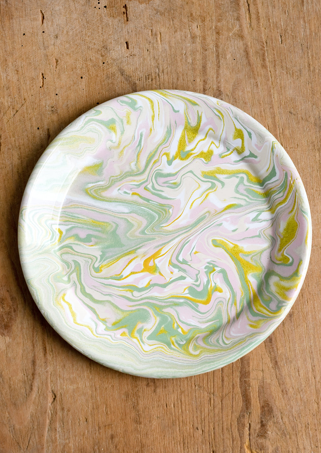 1: A round enamel plate with swirl pattern in pastel hues.