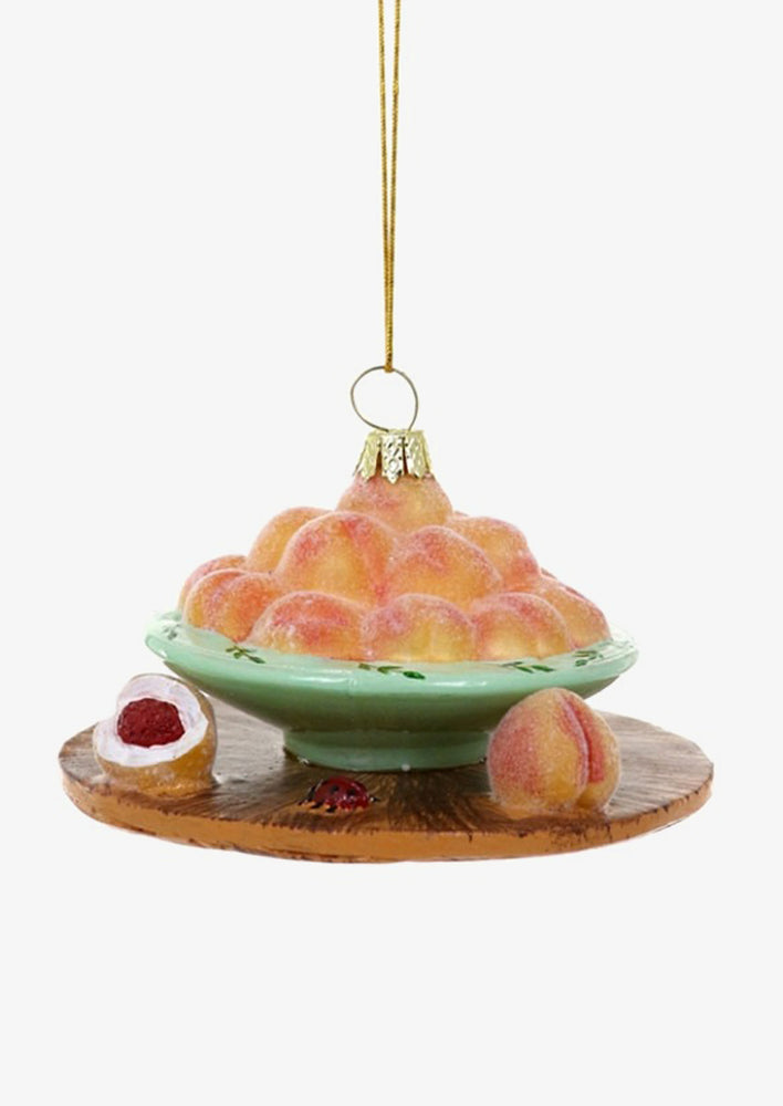 A holiday ornament of a bowl of peaches.