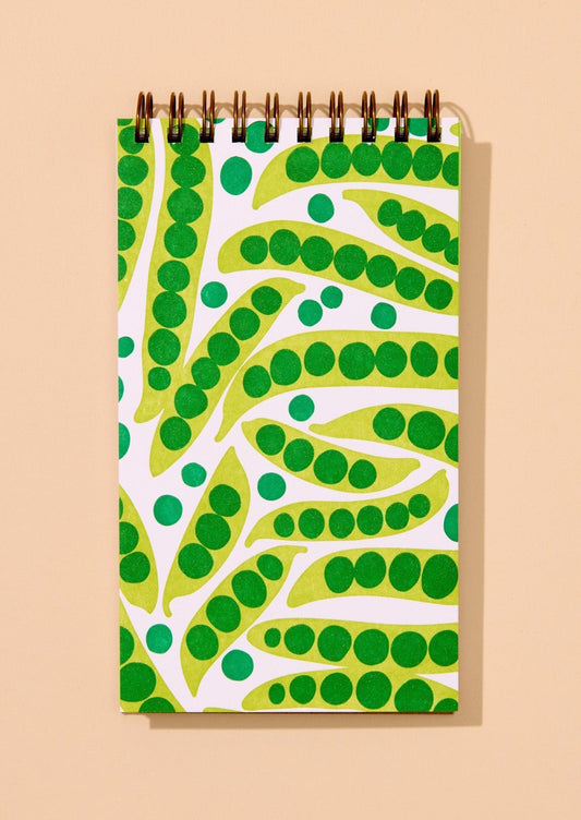 Notebook with green and white peapod pattern on a beige background
