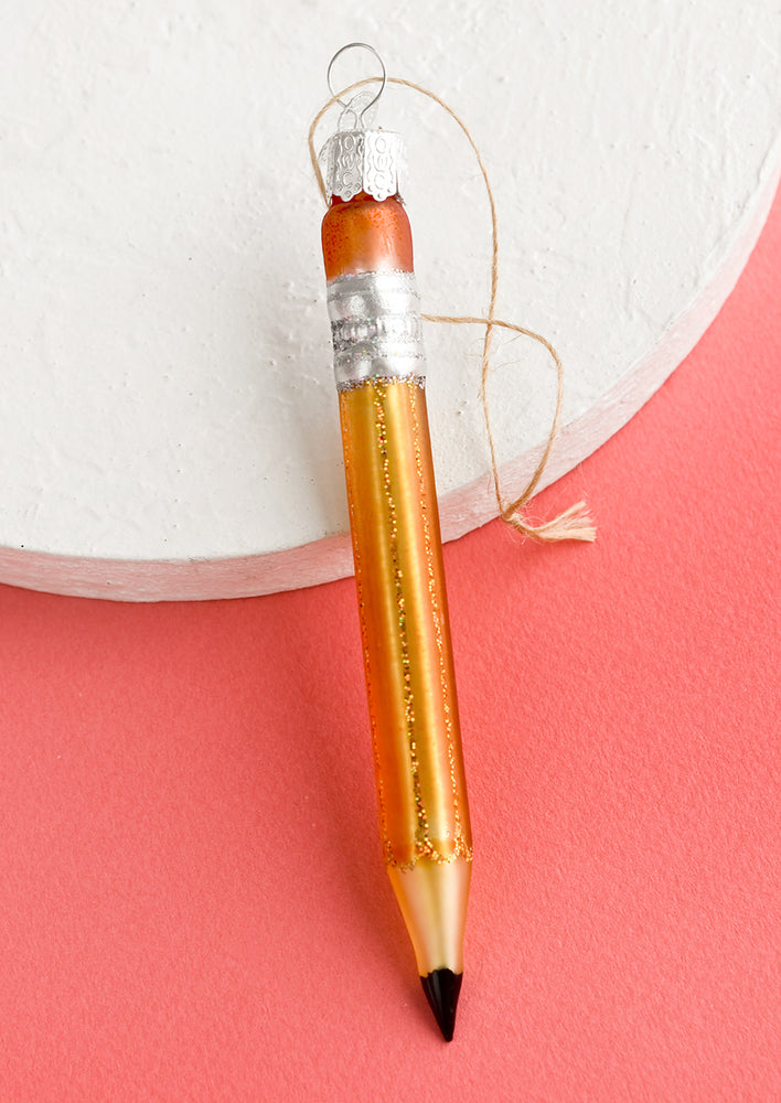 1: A glass holiday ornament of a pencil.