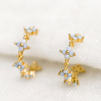 1: A pair of gold hoop earrings with periwinkle opal blue flowers.