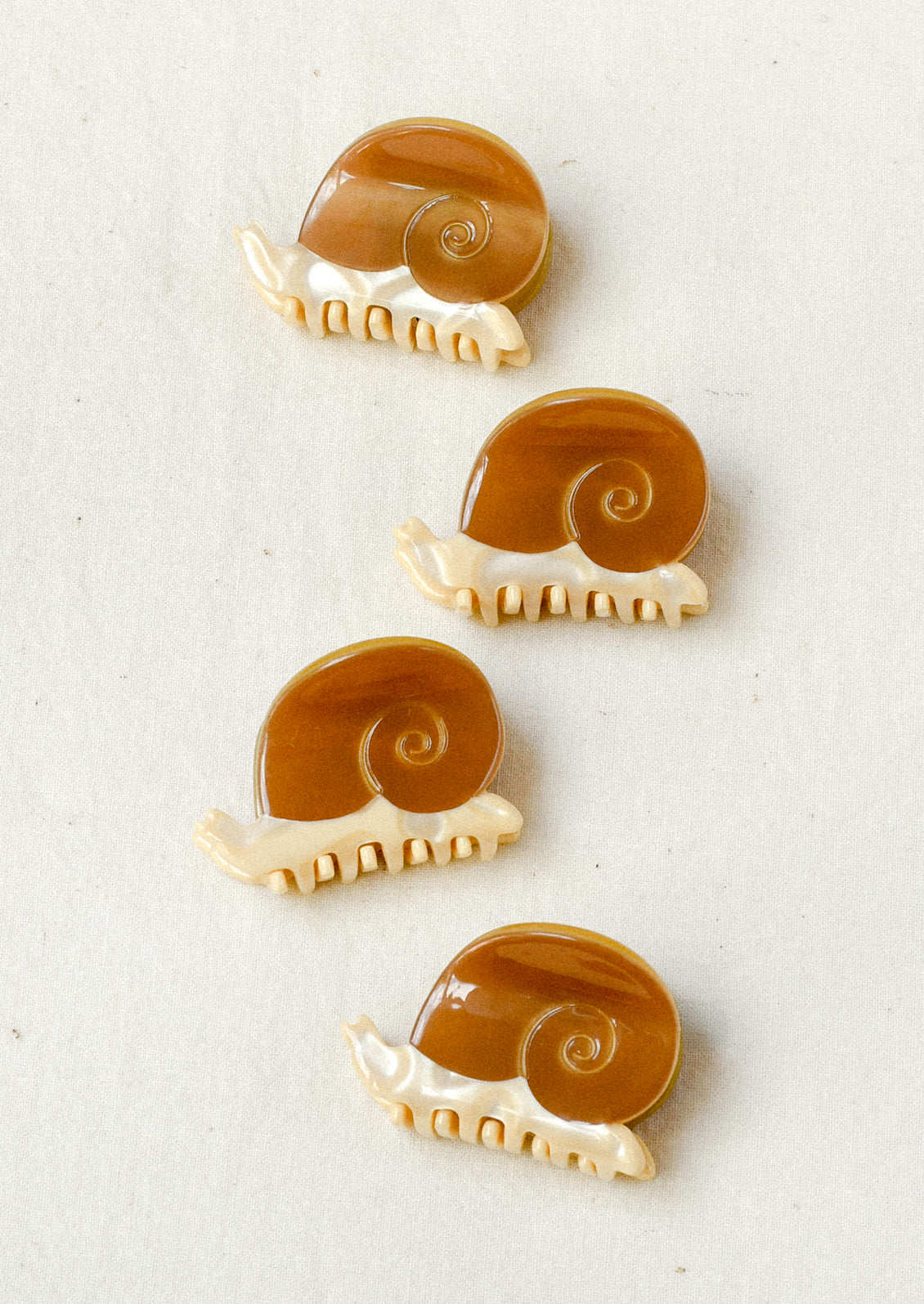 Four mini hair clips in the shape of snails.