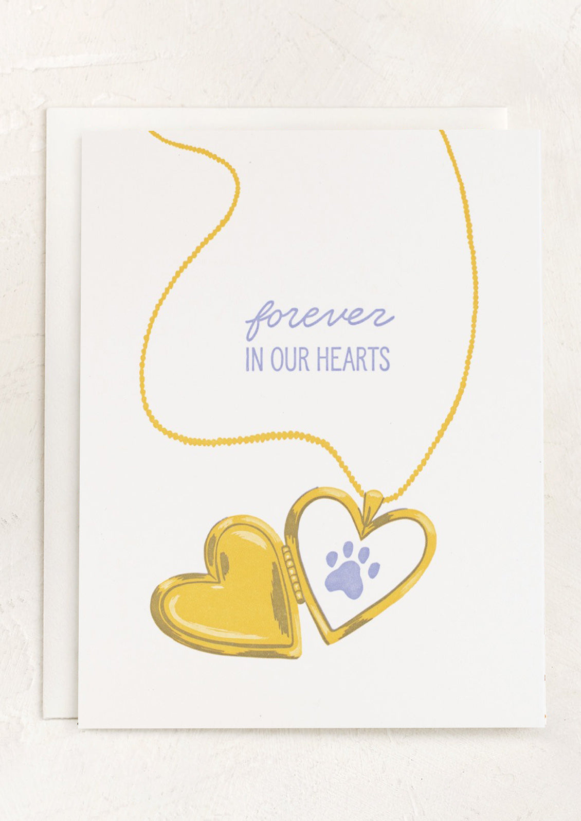 Heart-shaped locket necklace with paw print on a white card with 'forever in our hearts' text.