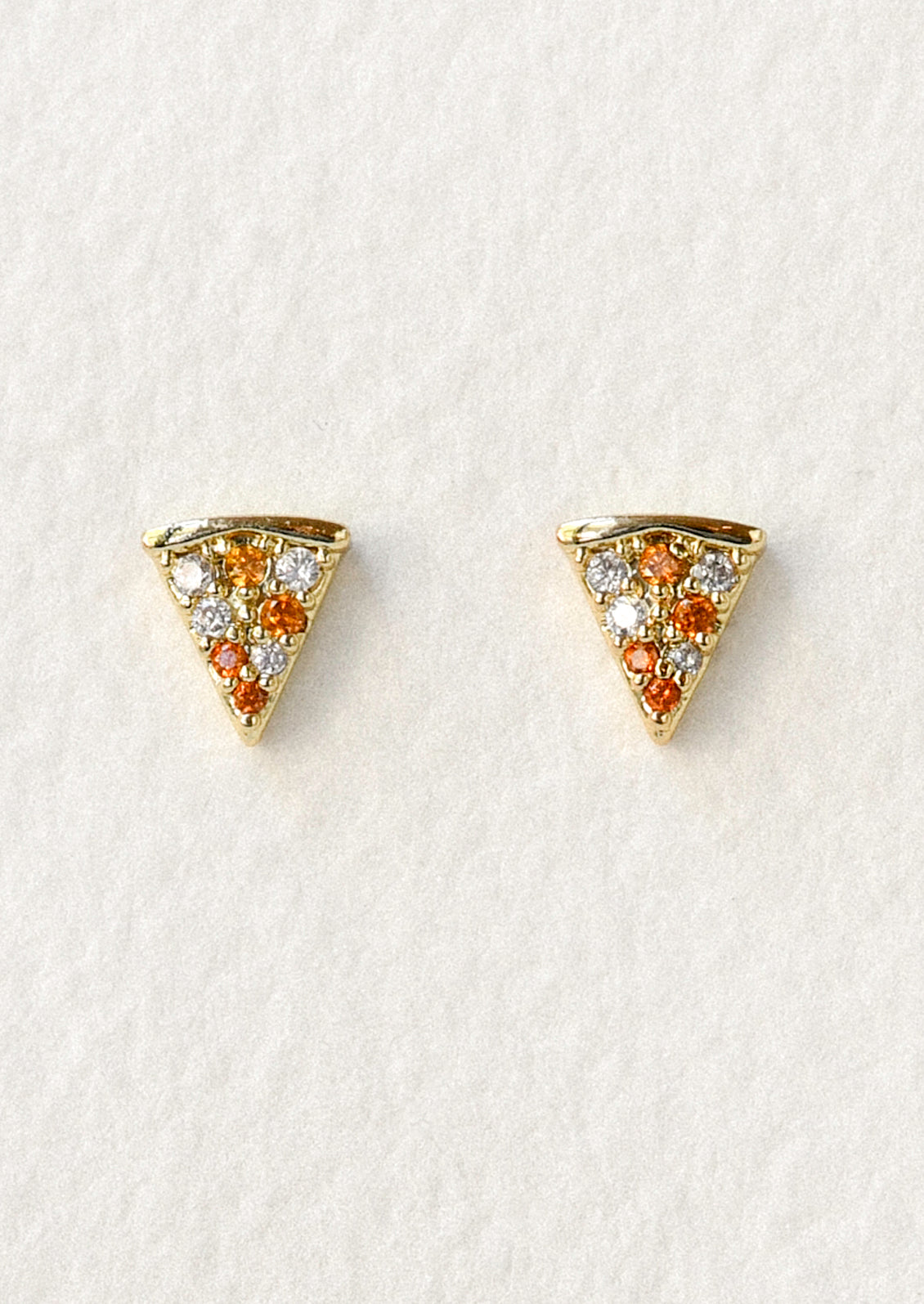 A pair of gold studs in the shape of pizza slices with red gems as the pepperonis.