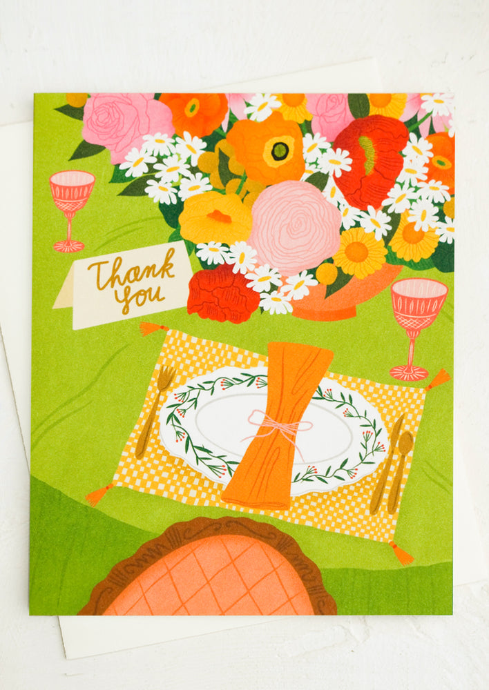 1: A card with image of place setting and place card that says "Thank you".