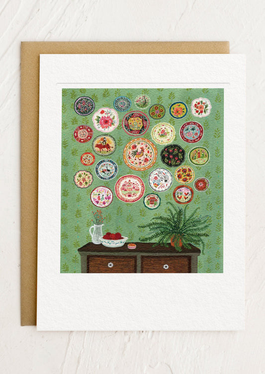 Decorative greeting card with a collage of colorful plates on a green background, framed with a brown border.
