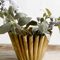 2: A pleated metal planter in distressed brass finish.
