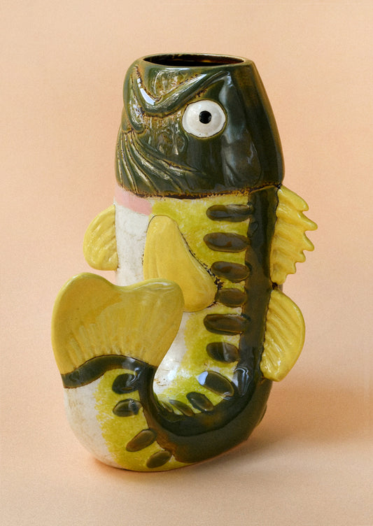A ceramic vase in the shape of a green and yellow trout.