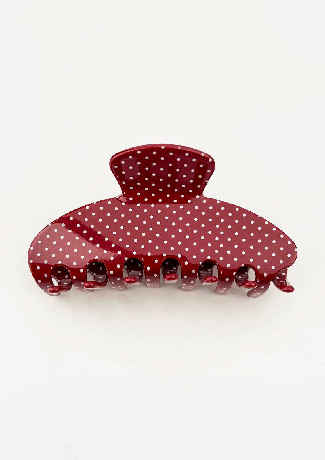 A burgundy hair claw with a light blue polka dot pattern.