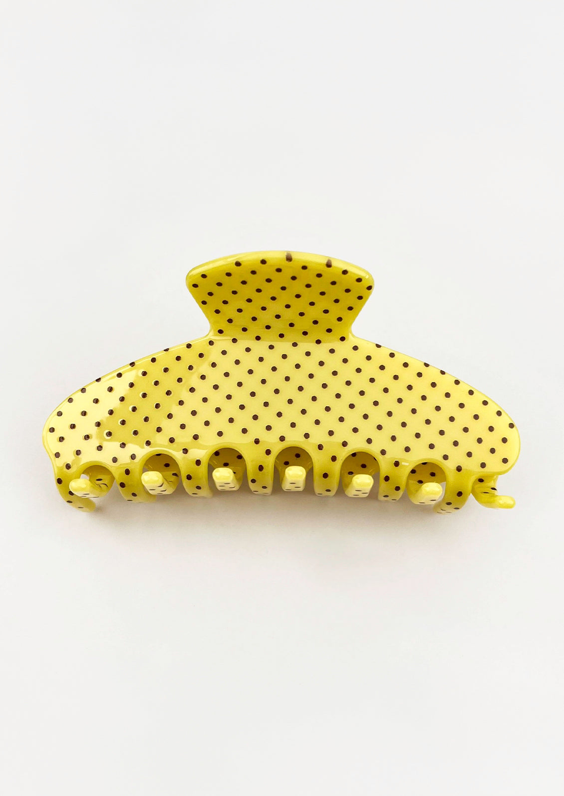 A yellow hair claw with a brown polka dot pattern.
