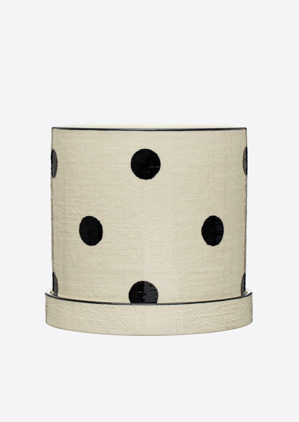 2: A polka dot ceramic planter in white with black dots, linen texture.