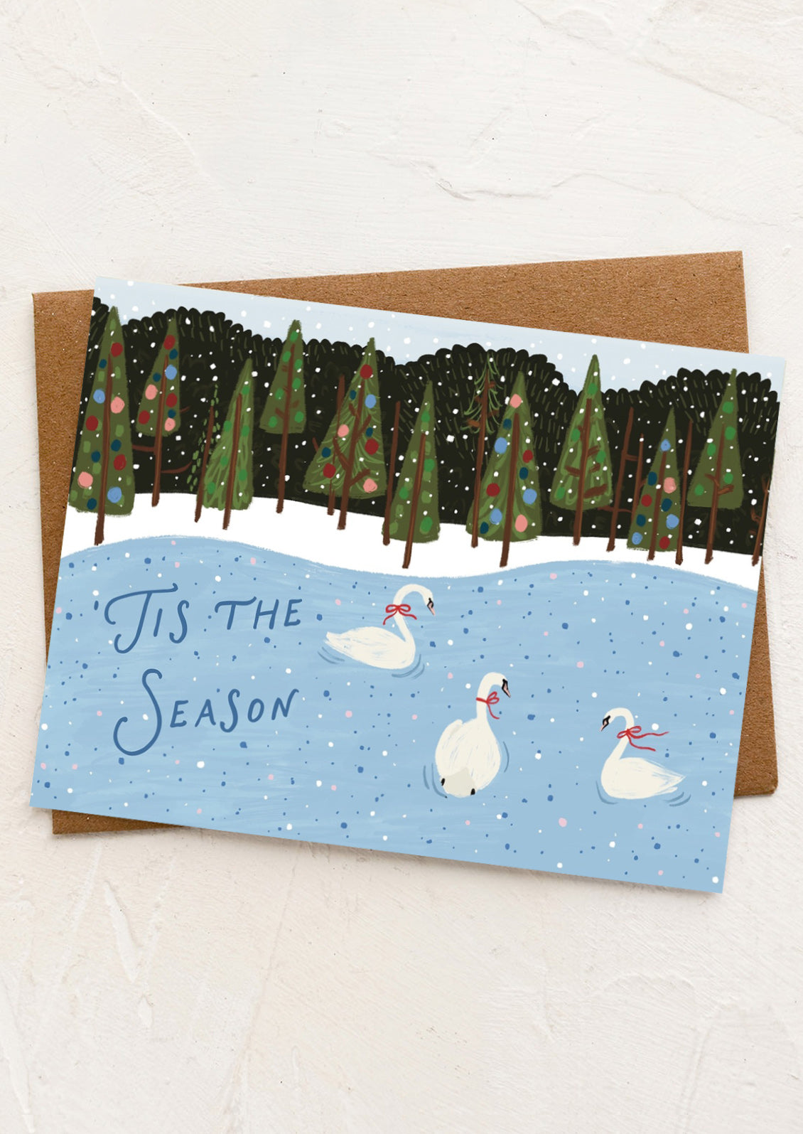 Holiday card with swans and Christmas trees on a snowy background