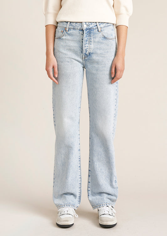 A person wearing a pair of light wash straight leg jeans.