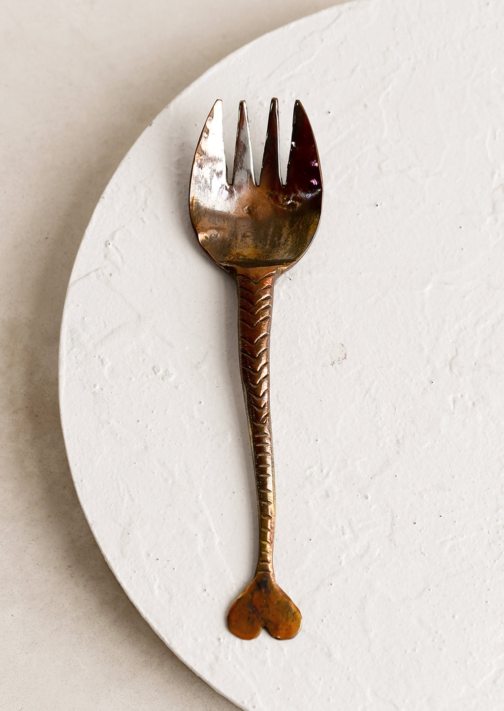 Fork: A copper fork with fish tail handle and oxidized finish.