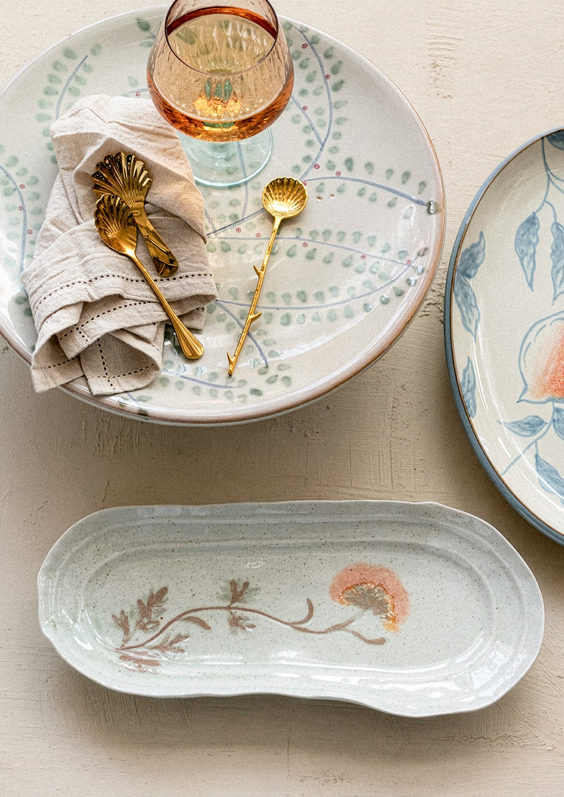 Ceramic platter with floral design on a table setting with plates and glasses.