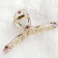 Purple: A clear crescent shaped hair claw with purple dried flowers.