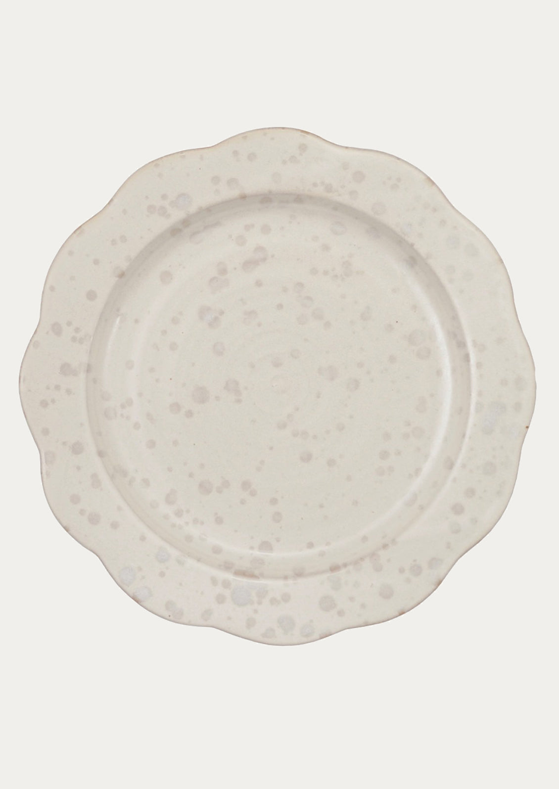 White ceramic plate with speckled gray pattern and scalloped shape.