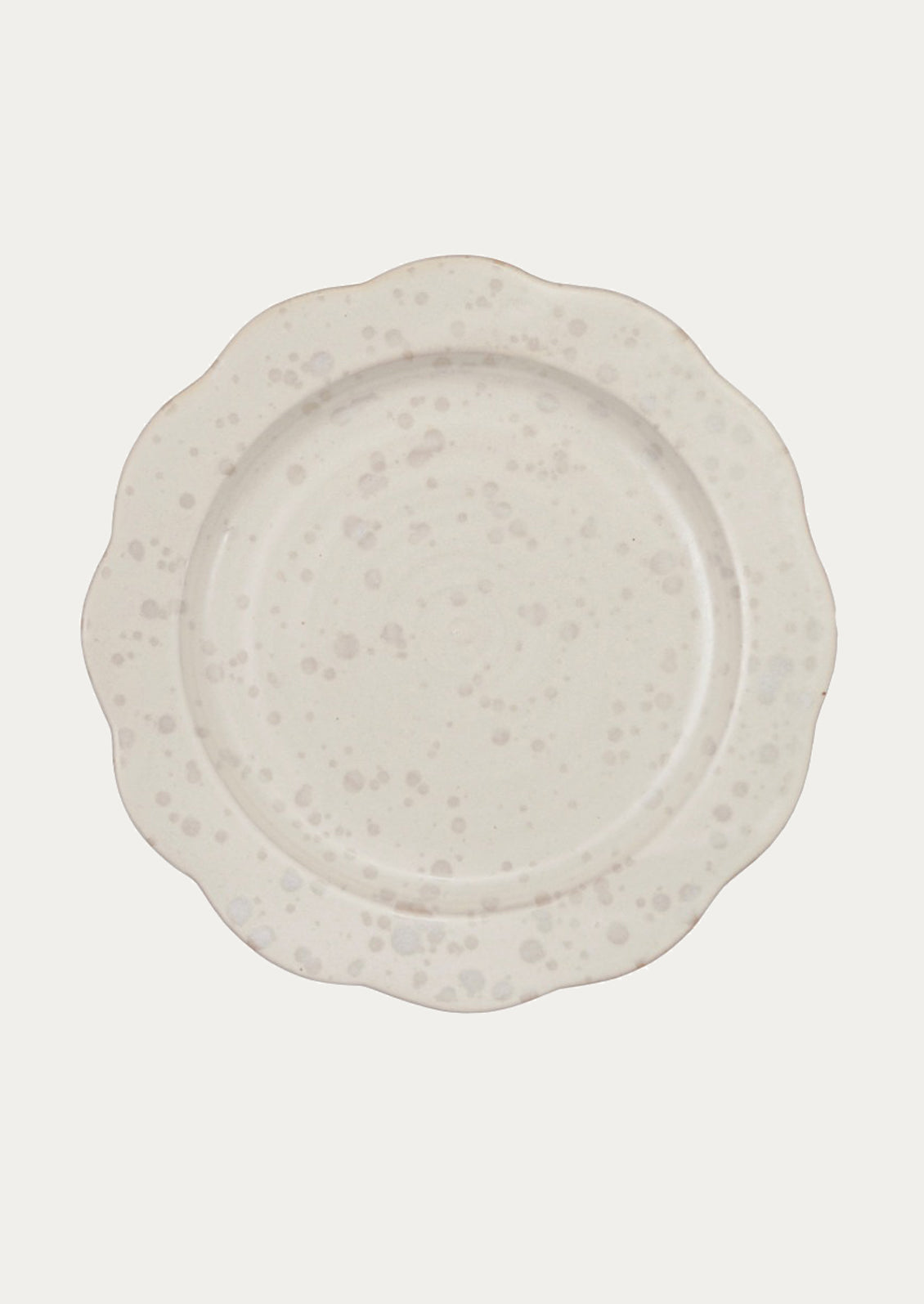 White ceramic plate with speckled gray pattern and scalloped shape.