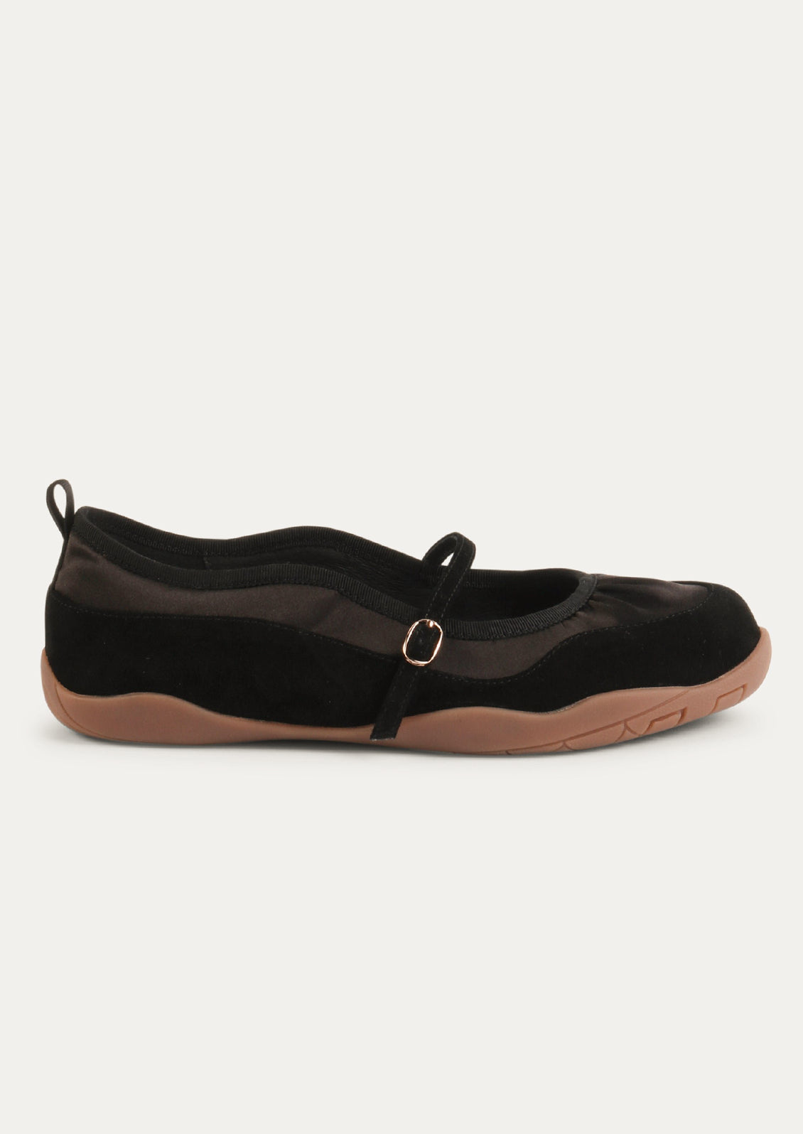 A black shoe that is part sneaker, part ballet flat mary jane. Suede/textile upper with a rubber gum sole.