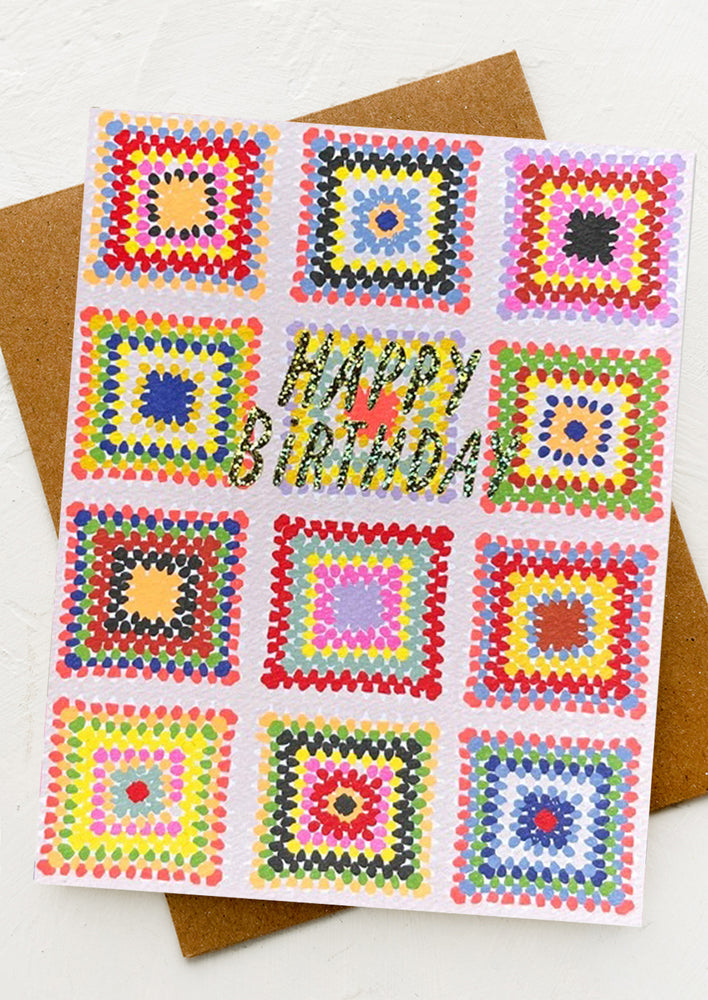 A colorful quilt print card with glitter text reading "Happy birthday".