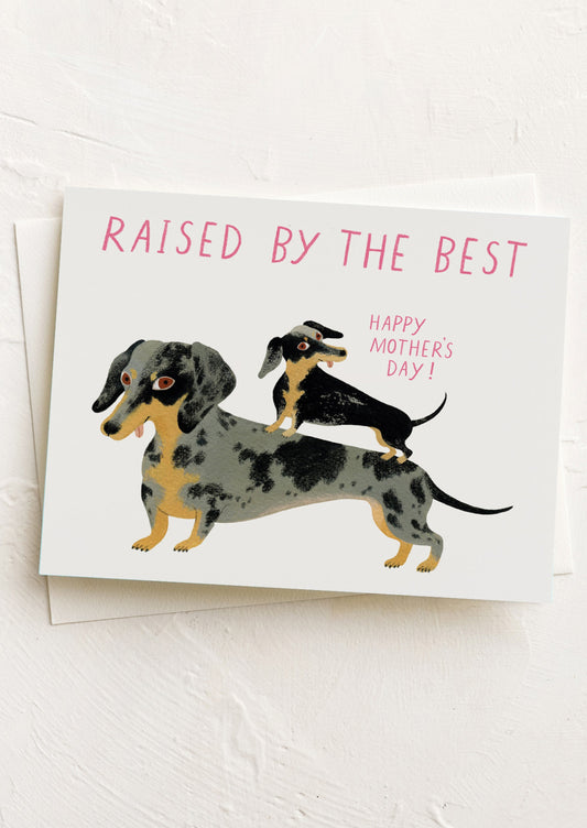 Greeting card with dachshunds and text 'Raised by the best. Happy Mother's Day!' on a white background