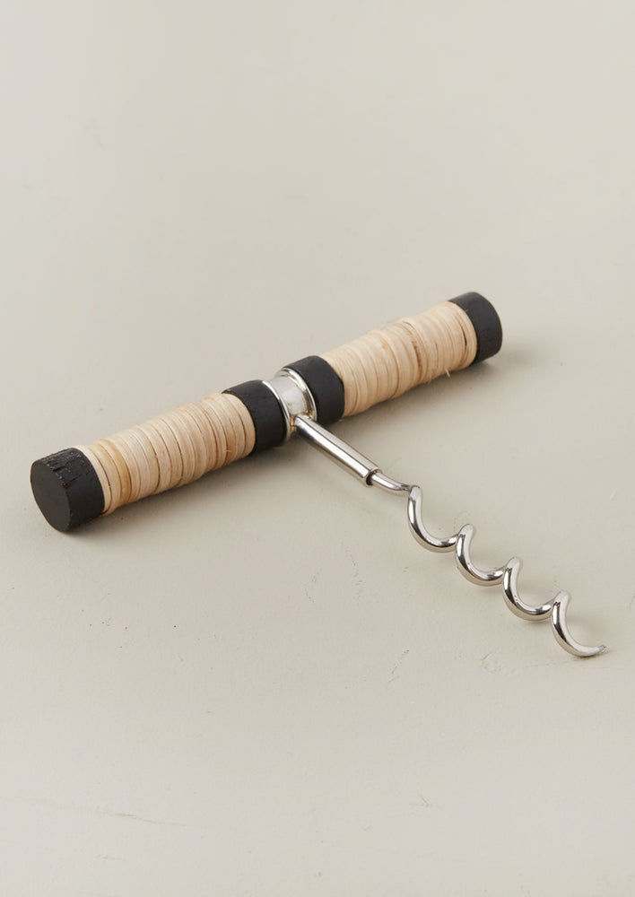 A stainless steel corkscrew with rattan bar-shaped handle.