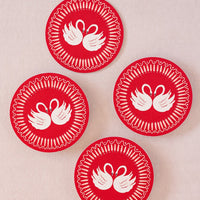 Red Swan: A set of paper coasters in red swan print.